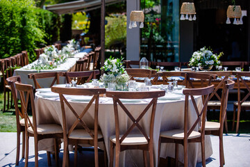 Wedding organization preparation restaurant and wedding planners.Chairs and honeymooners table decorated with candles, served with cutlery and crockery and covered with a table cloth. wedding area