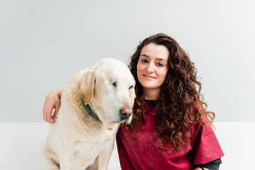 Veterinary woman next to a Labrador Retriever breed dog in the clinic consultation. health and pet care.