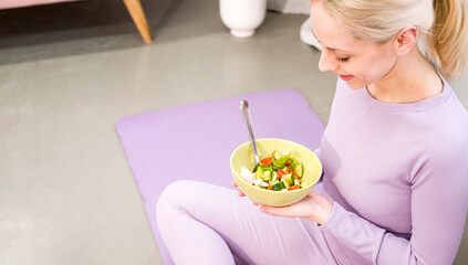 Closeup of a Young woman eating a healthy salad after workout. Fitness and healthy lifestyle...