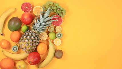Detox diet and weight loss concept. summer tropical fruits and vegetables on a yellow table, top view, healthy and natural food, source of vitamin C, store banner, selective focus, space for text
