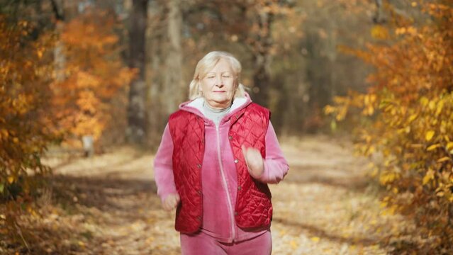 Positive senior woman jogging to lose weight, doing cardio, healthy lifestyle