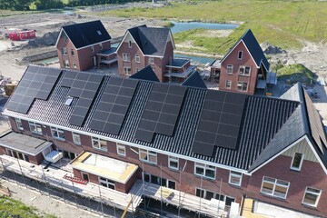 Newly built well-insulated houses with black solar panels and heat pumps for economical energy...