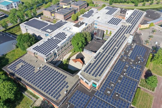Drone photo of a large school building for vmbo, mavo ,havo and vwo education.
1100 solar panels have been installed on the roof of this school for green energy.