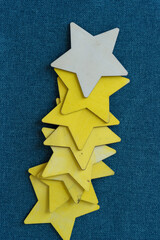 grungy wooden stars (some yellow) layered over one another on blue fabric