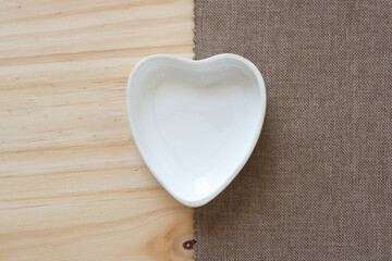 heart shaped dish partly on fabric, partly on wood