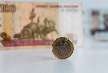 One euro coin close-up on blurred background of One hundred russian rubles