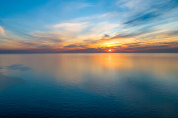 Aerial view of setting sun over calm sea with text space - minimalism in nature