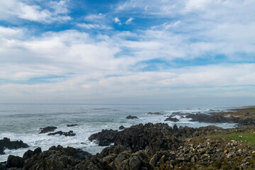 Fototapeta na wymiar Beach view with ocean rocks on the coast
