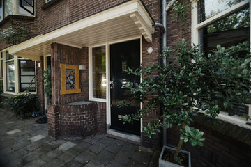 Fototapeta na wymiar Beautiful house facade. Black door and surrounding architecture, Holland.