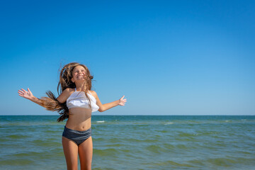 Flying jump beach little happy girl on blue sea shore in summer vacation