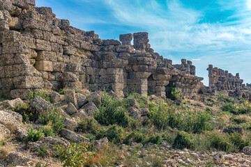 Fototapeta na wymiar ruins of ancient city walls against the backdrop of the sky with moon in Side, Turkey