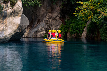 Fototapeta premium tourists on an inflatable boat rafting down the blue water canyon in Goynuk, Turkey