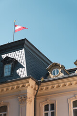 Fototapeta na wymiar Hotel Fassade mit Österreich Flagge vor blauem Himmel | Bad Gastein, Österreich