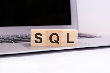SQL - wooden cubes with letters on a laptop keyboard