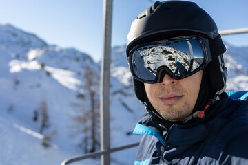 ski resort man on chairlift in helmet and mask