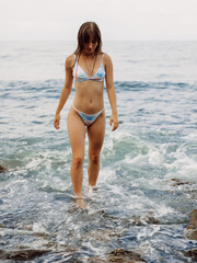 Attractive woman in bikini at sea coastline.