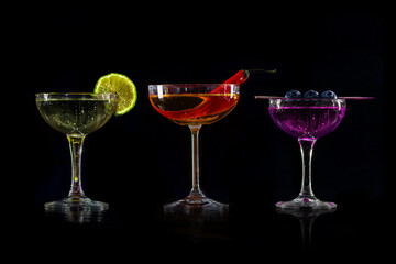 Set of coctails on bar counter in a restaurant, pub. Collection of fresh juice alcoholic drinks. Cooler beverage isolated on black background