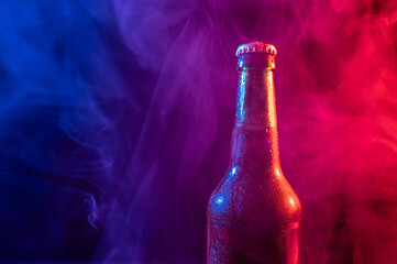 Glass bottle of beer in blue pink mist