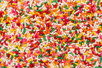 Fototapeta na wymiar Top view of multicolor rainbow sprinkles. Colorful sprinkles sugar background. Sugar sprinkles is for decoration cake and other bakery items.