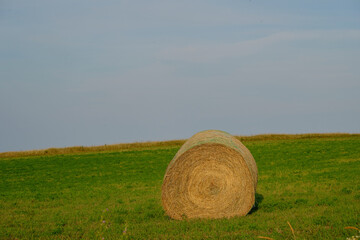 Evening falls on a hay bale at the edge of the ocean on Prince Edward Island in Canada