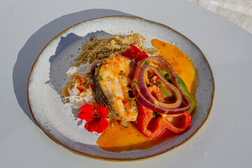 white salmon with gourmet sauce and rice with vegetables decorated with flowers