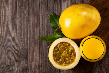 Glass with passion fruit juice and sliced ​​passion fruit on the table.