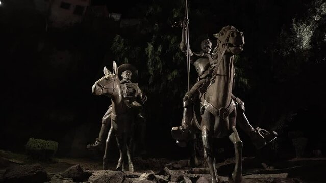 Statues of two symbolic Mexican soldiers riding a horse and a donkey at night in downtown 