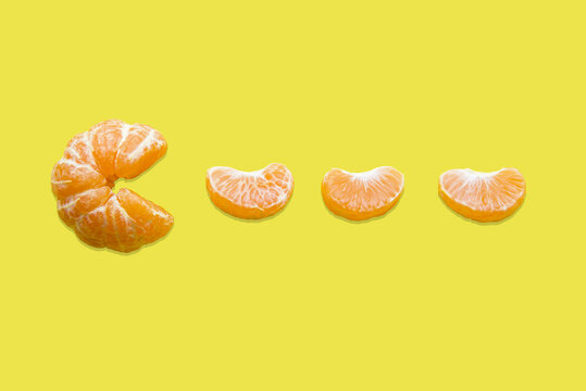 Mandarin And Mandarin Slice On A Yellow Background. Pacman Game. Tangerine Pacman. Vitamin C