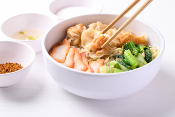 Noodles soup with wonton dumpling and grilled red pork in bowl on white background, Asian food