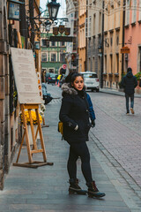 Brunette in Black Coat Stands Outside of Restaurant in Warsaw, Poland