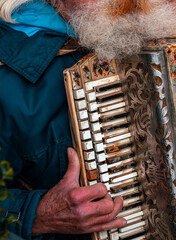 Old Polish Street Performing Man with bushy beard playing the accordion in Poland