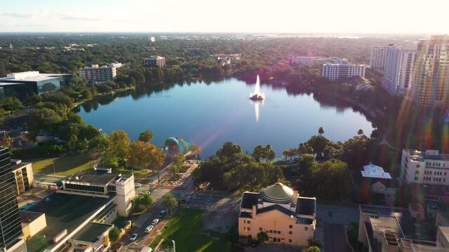 Cinematic drone video orbiting above Lake Eola during sunrise in downtown Orlando.