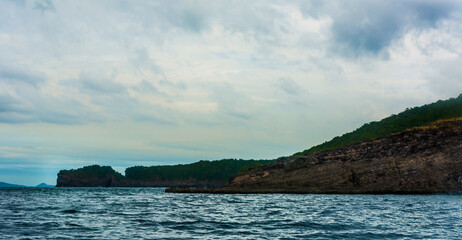 Fototapeta na wymiar Rock Island over scenic blue sea water.