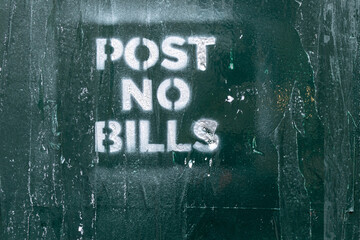 Post no bills sign on green wall