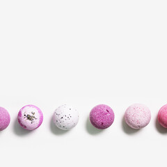 Flat lay composition with bath bombs pink, violet color on white background. Bathing balls with lavender essential oil for relaxation and aromatherapy. Body care natural products.