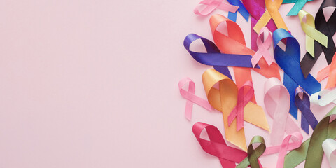 Multicolour ribbons on pink background, cancer awareness, World cancer day - 483510492