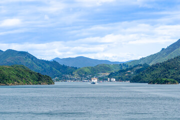 One of New zealand's inter-island ferry leaving picturesque landscape and small township behind