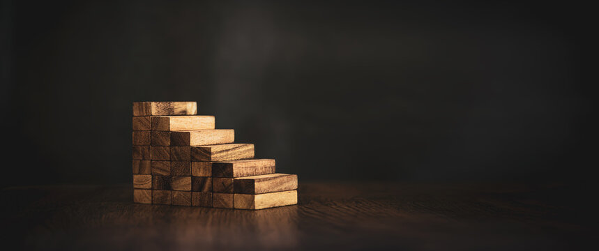 Close-up wood toy block tower stack in pyramid stair step concepts of financial risk management prevent and strategic planning.