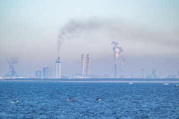 海岸線と煙が出る工場の風景