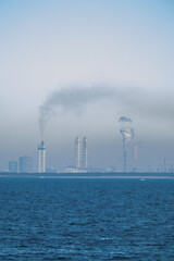 海岸線と煙が出る工場の風景