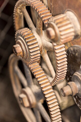 Old metal gears interlocking on the outside of a piece of machinery