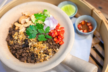 Chinese Black Olive Stir-fried Rice minced pork with cashew nut delicious Chinese food served in a white clay pot selective focus.
