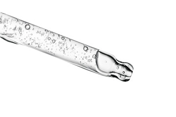 Transparent pipette with cosmetics on a white isolated background.