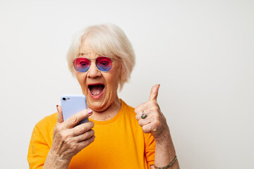 Photo of retired old lady in casual t-shirt sunglasses talking on the phone close-up emotions