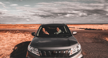 Front View of Couple Driving in Car in Remote Land in Iceland - obrazy, fototapety, plakaty
