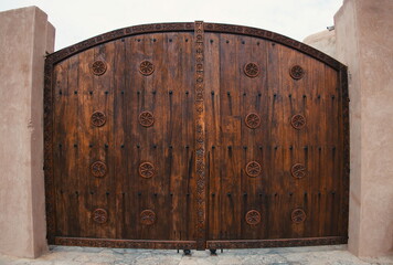 Wooden door with arch in Oman - public places