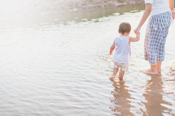Mother and daughter walking on the beach.