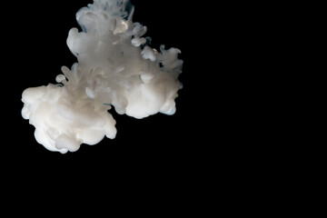 white liquid drop in clear water with lighting, look like smoke in the night.