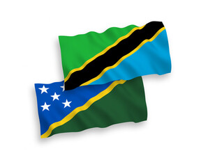 National vector fabric wave flags of Solomon Islands and Tanzania isolated on white background. 1 to 2 proportion.