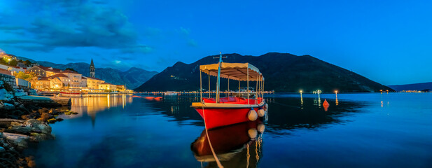 Sunset panorama of Kotor Bay and a docked boat in the town of Perast, Montenegro